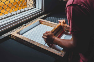 Close up of a man screen printing.