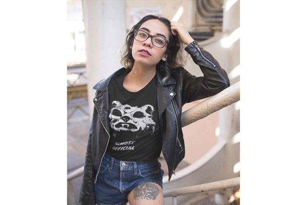 A young cool woman wearing a leather jacket and the Hombre Lobo shirt that depicts an abstract werewolf face.