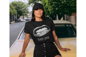 A woman leaning against a classic car while wearing the Pearly Whites shirt depicting a crude mouth cutout.